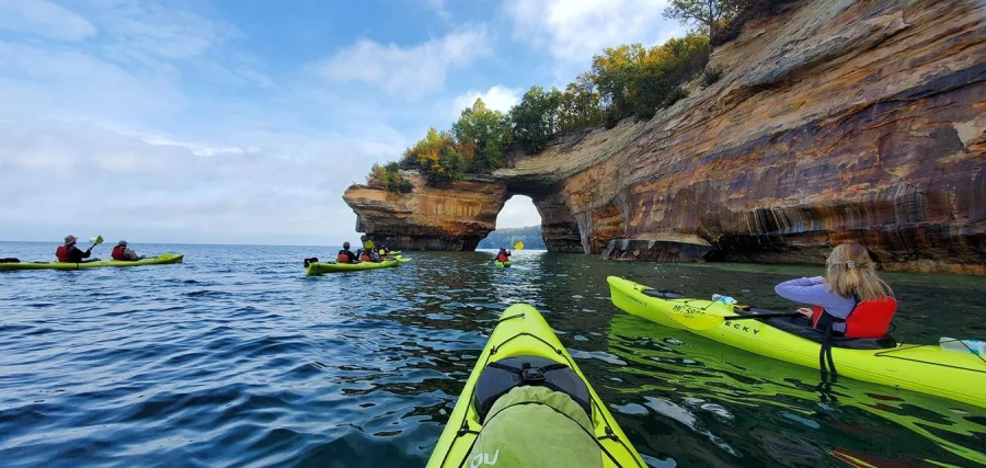Kayakers paddling underneath the popular Lovers Leap archway in the Pictured Rocks