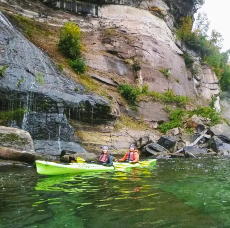 Kayakers near one of the many waterfalls found along the cliffs on Grand Island