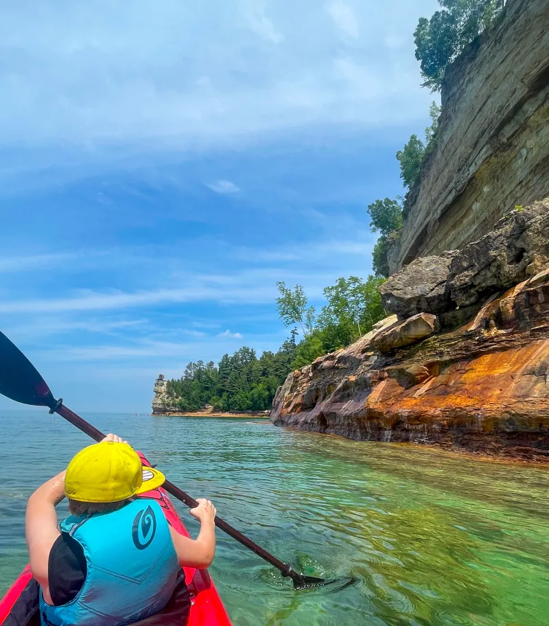 Kayaking next to a towering Pictured Rocks Cliff