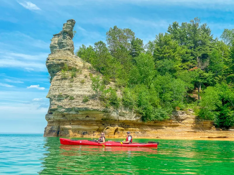 Kayakers in front of Miners Castle in Pictured Rocks, a tall rock formation rising up from Lake Superior